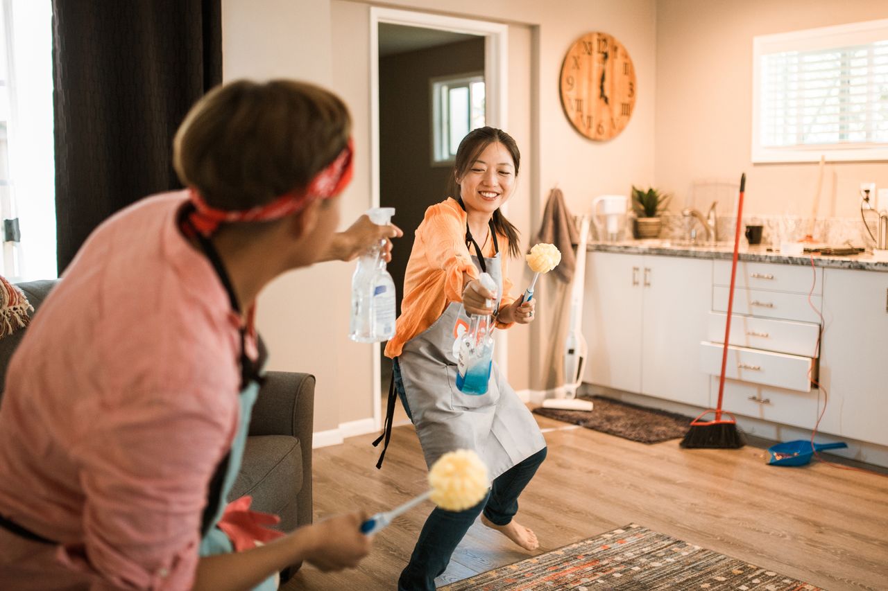 home-img Asian couple having fun while cleaning their home, enhancing a cheerful atmosphere.